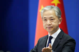 穿西裝男子在記者會上發言，身後有中國國旗。 — 中文 壁紙
