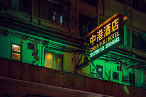 夜晚城市建築上發出綠光的霓虹酒店招牌。 — 唐人街 GIF 壁紙