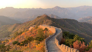 長城蜿蜒穿過秋山，金色夕陽映照。 — 中國 壁紙