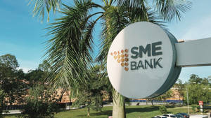 SME Bank標誌被棕櫚樹和綠植環繞，背景是晴朗的藍天。