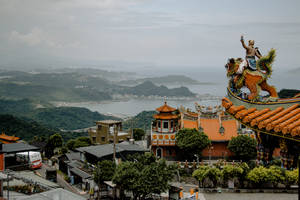 寺廟與龍雕像，俯瞰沿海城鎮和山脈 — 唐人街 GIF 壁紙