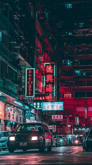 霓虹招牌照亮夜晚潮濕的城市街道，汽車駛過。