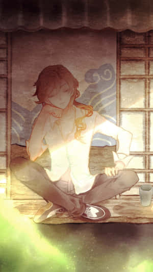 動漫男孩在室內窗邊盤腿而坐，有杯子和溫暖的光線。