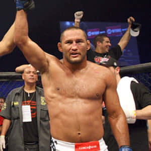 MMA拳手在八角籠中高舉雙臂慶祝勝利。