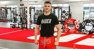 健身房的運動型男子穿著 'RAIDER' 襯衫和短褲