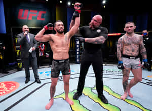 UFC拳手贏得比賽，裁判在八角籠中舉起他的手。