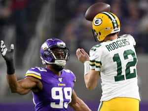 NFL四分衛亞倫羅傑斯傳球，明尼蘇達維京人防守球員丹尼爾亨特防守。