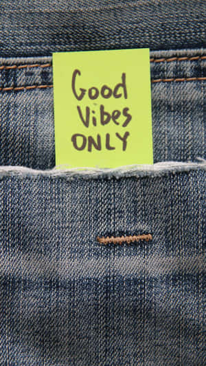 一張黃色便利貼，上面寫著 Good Vibes ONLY，放在牛仔褲口袋裡。