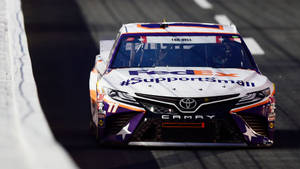 FedEx Toyota Camry賽車在賽道上飛馳，帶有星星貼紙和贊助商標誌。