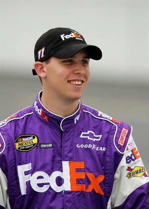 身穿紫色FedEx賽車服的NASCAR車手對著鏡頭微笑