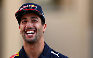 賽車手戴著Red Bull Racing帽子和團隊衫大笑。 — 微笑 壁紙