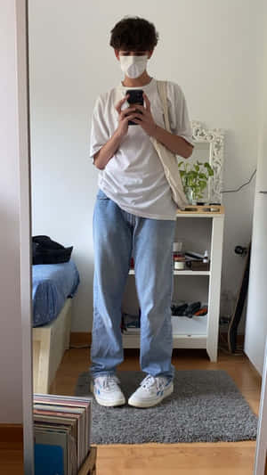 穿著白色T恤和牛仔褲的人在臥室裡對著鏡子自拍，臥室裡有床和植物。 — 美學男孩 壁紙