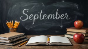 學校書桌上有書本、鉛筆和蘋果，前面是寫著「September」的黑板