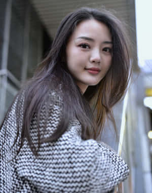 穿著千鳥格毛衣的年輕女性在戶外面對鏡頭