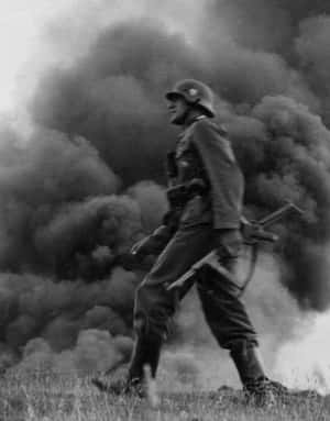 戰爭期間，士兵在草叢田野中穿過濃煙行走。