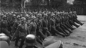 身穿制服的士兵在閱兵式中持步槍列隊行進。