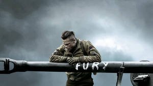 穿制服的士兵倚靠在標有 fury 的坦克炮管上，天空風暴