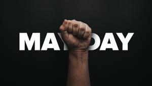 舉起的拳頭穿過黑色背景上的 MAYDAY 字樣。