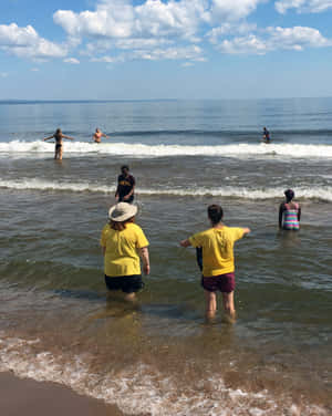 一群人在陽光明媚的海灘日享受海浪。 — 湖 壁紙