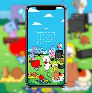 手機屏幕顯示BT21角色在公園演奏音樂，並帶有五月日曆。