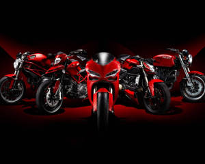 五輛紅色Ducati電單車在工作室中以戲劇性的紅色燈光展示。 — 1920x1080 壁紙