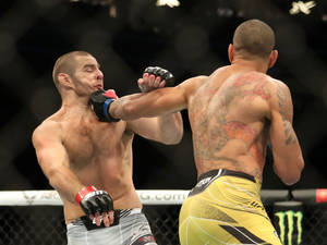 兩名男性MMA拳手在八角籠中比賽時互相出拳。 — 黃色 壁紙