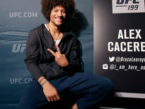 UFC拳手Alex Cacere在活動中微笑並做出和平手勢。