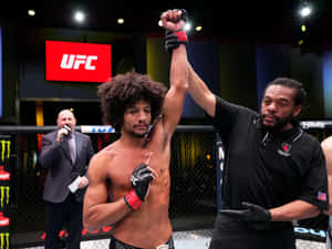 UFC拳手贏得比賽，裁判舉起他的手表示勝利。 — 冠軍 壁紙