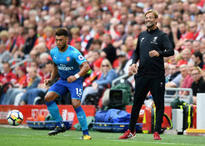 足球員運球，教練在場邊觀看。 — 運動 壁紙