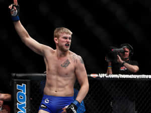 UFC拳手在八角籠內高舉手臂慶祝勝利。