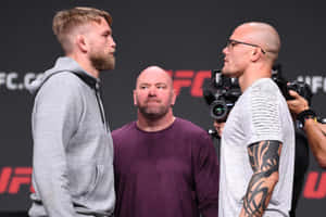 兩名男性UFC拳手在記者活動中對峙，周圍有相機。