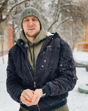 男人戴著冷帽和外套站在雪地戶外場景中