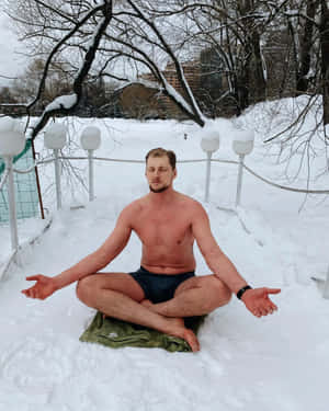 男子在雪地中冥想，周圍有光禿的樹木和燈籠