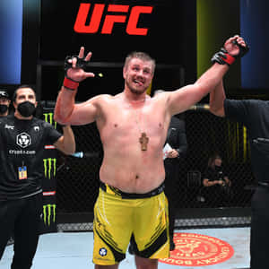 UFC拳手在八角籠中舉臂慶祝勝利。