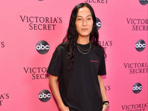在Victoria's Secret活動中身穿黑色T恤和金色項鍊的人。