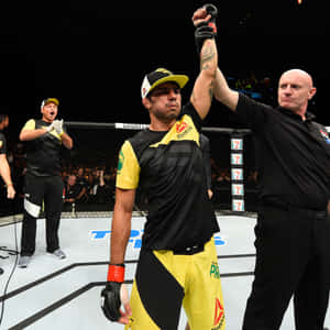 MMA選手在八角籠中慶祝勝利，裁判舉起他的手。