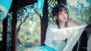 身穿傳統漢服的年輕女子坐在木亭中，周圍綠意盎然。 — 亞洲 壁紙