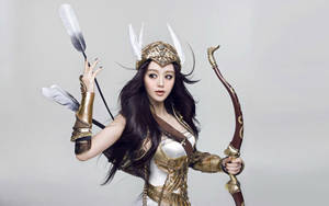 一位身穿金色盔甲、打扮成幻想弓箭手的女性，手持弓箭。 — 亞洲 壁紙