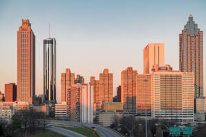 亞特蘭大天際線在夕陽下，摩天大樓和下方高速公路上的橙色光
