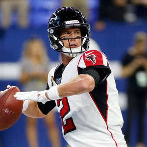 亞特蘭大獵鷹隊四分衛在夜間比賽中擲出橄欖球。 — NFL 美式足球 GIF 壁紙