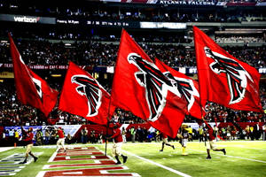 Falcons 足球隊旗幟在夜間比賽中被球員在場上揮舞。