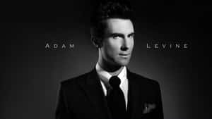 Adam Levine 身穿黑色西裝打領帶，附文字疊加 — 16:9 壁紙