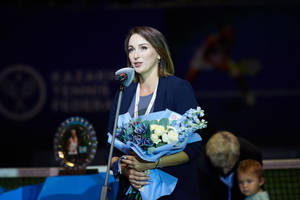 女性手持鮮花在頒獎典禮舞台上發言。 — 網球 壁紙