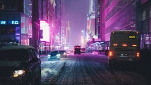 夜晚積雪的城市街道，被鮮豔的霓虹燈和車頭燈照亮。 — 淺紫色動態圖片 壁紙