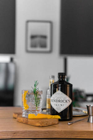 Hendrick's氈酒瓶和迷迭香柑橘雞尾酒在木板上。