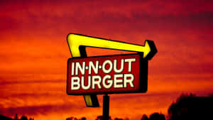 In-N-Out Burger 招牌，黃色箭頭，火紅日落天空