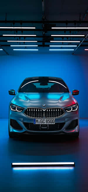 銀色BMW汽車在現代車庫中被藍色霓虹燈照亮。 — iPhone 18 壁紙