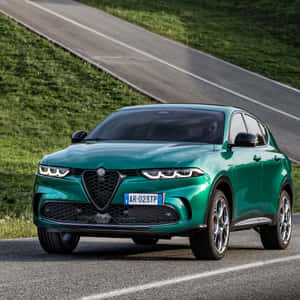一輛綠色Alfa Romeo SUV在蜿蜒的道路上，兩旁是草坡。