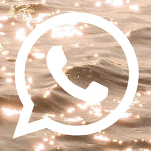 閃爍的金色水面上的白色WhatsApp標誌。