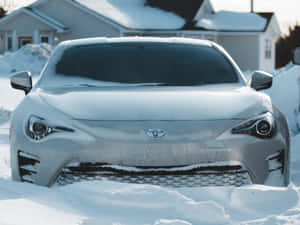 銀色跑車被雪覆蓋在一個積雪的住宅區。
